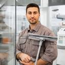 Tecnico delle pulizie con attrezzatura professionale vicino a vetri e superfici riflettenti in un negozio